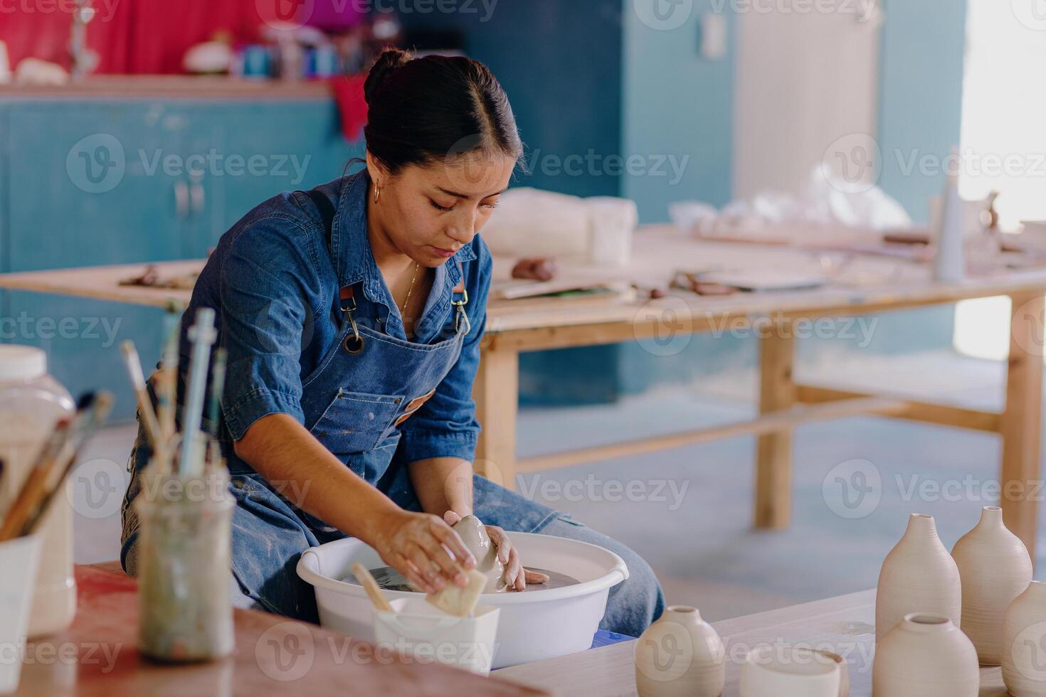 a mexican woman is making pottery in a studio photo