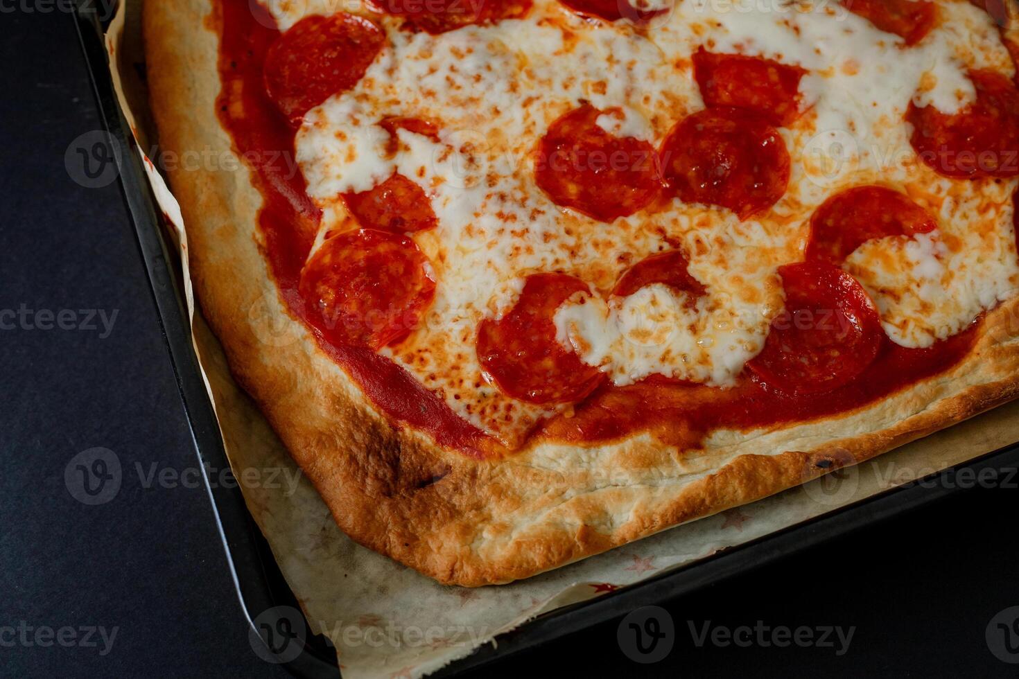a pizza with pepperoni on top of a pan photo