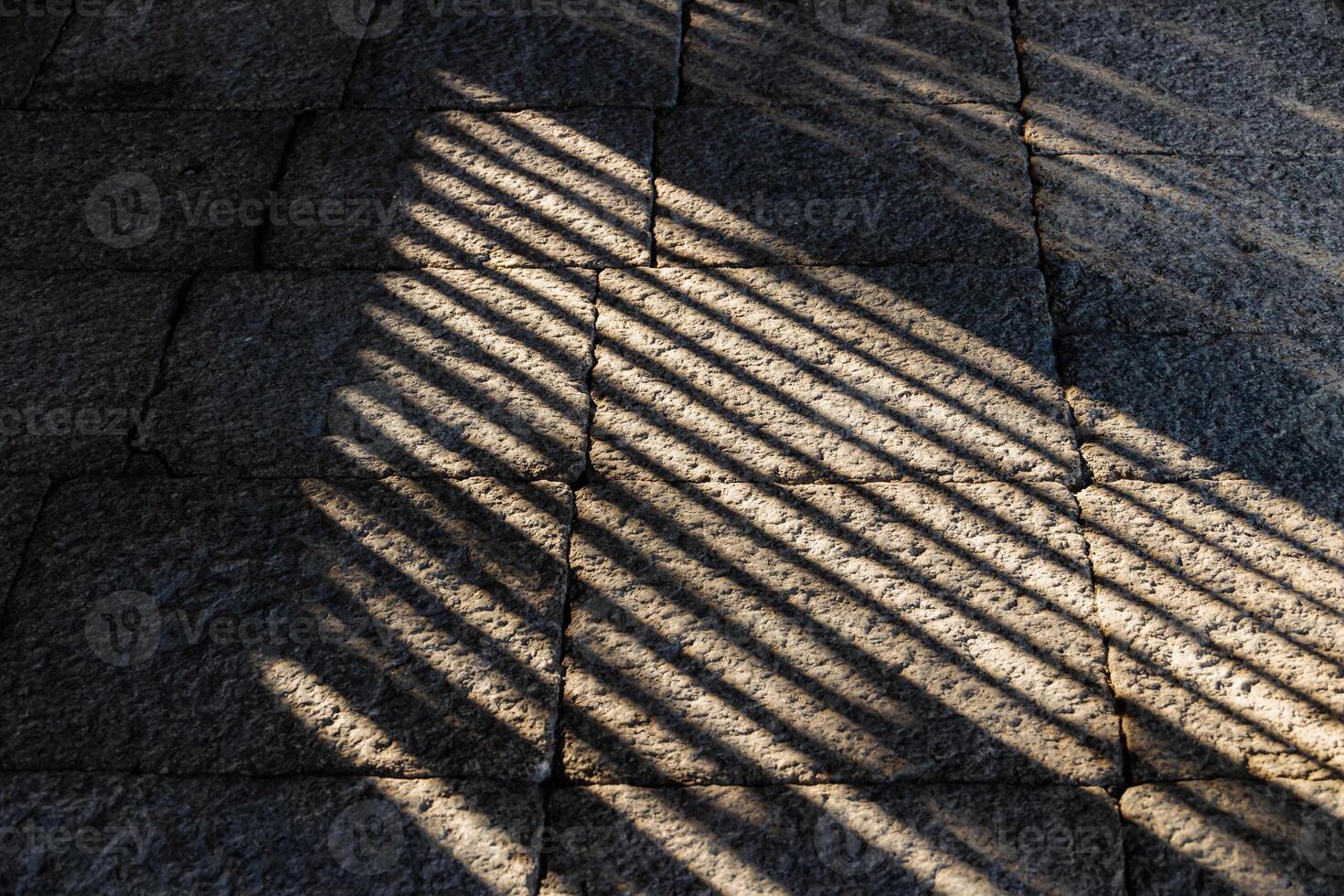 A man sitting on a bench with his back to the sun photo
