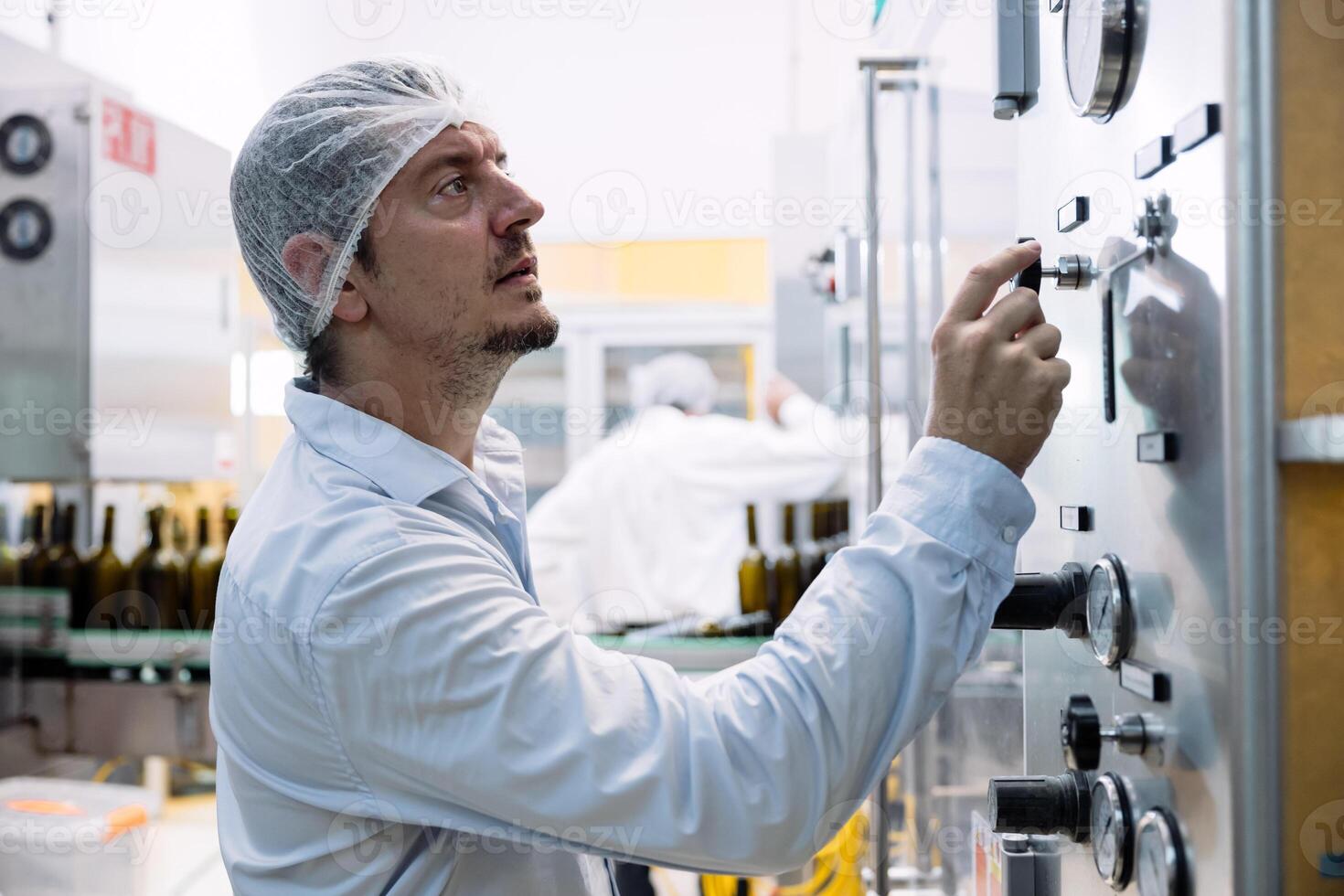 A man in a white hat is working on a machine photo