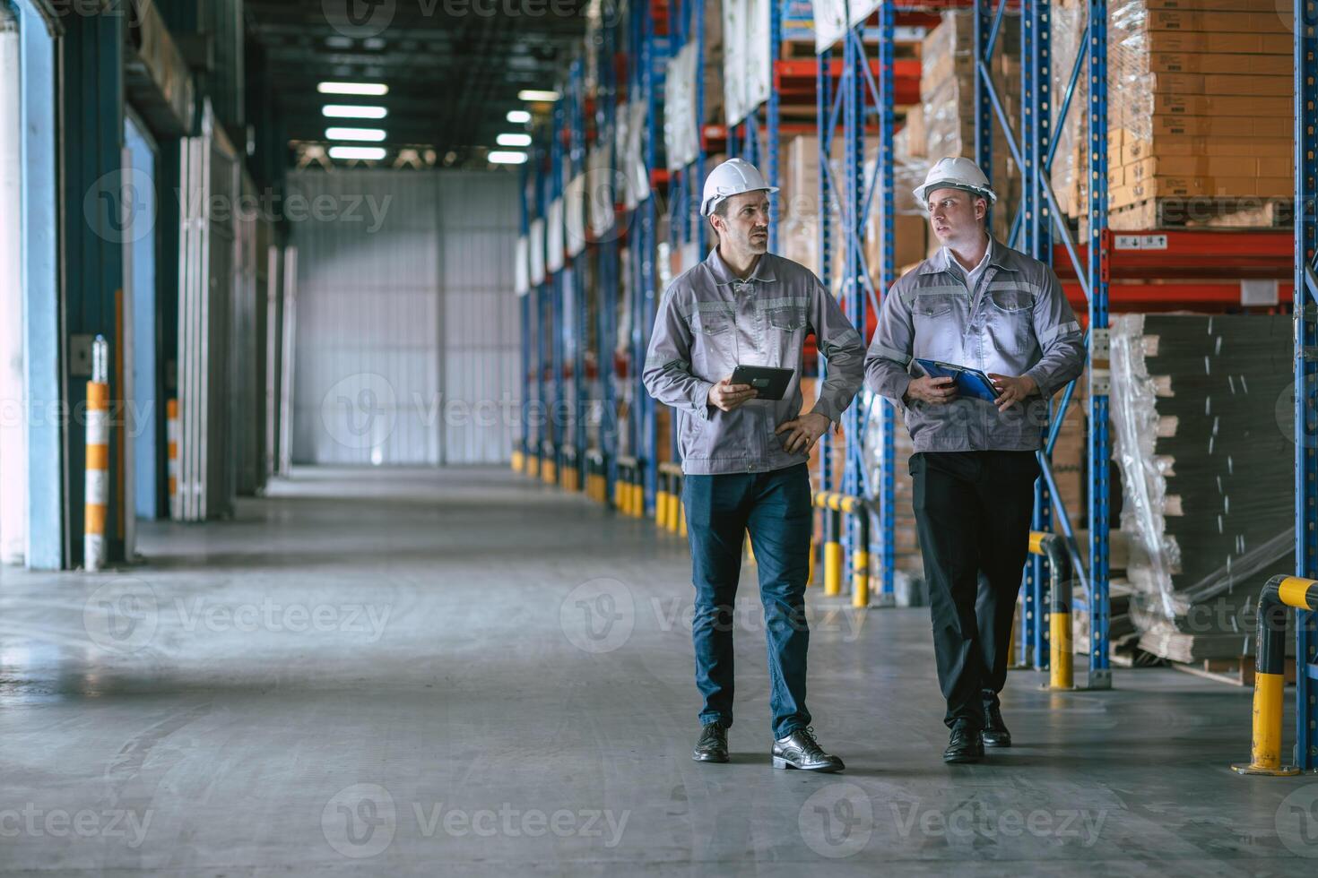 Two men in hard hats walking in a warehouse photo