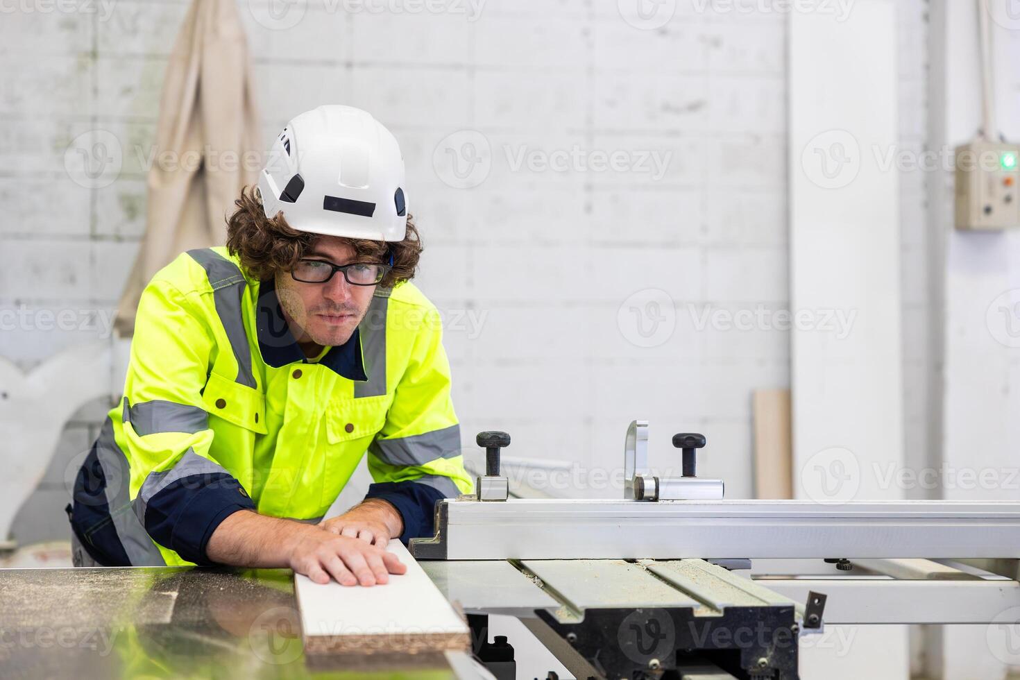 male employee male staff worker cutting wooden board on wood workbench in furniture factory photo
