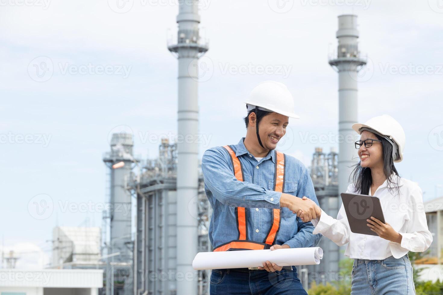 Asian engineer and asian female engineer working together in front of power plant photo