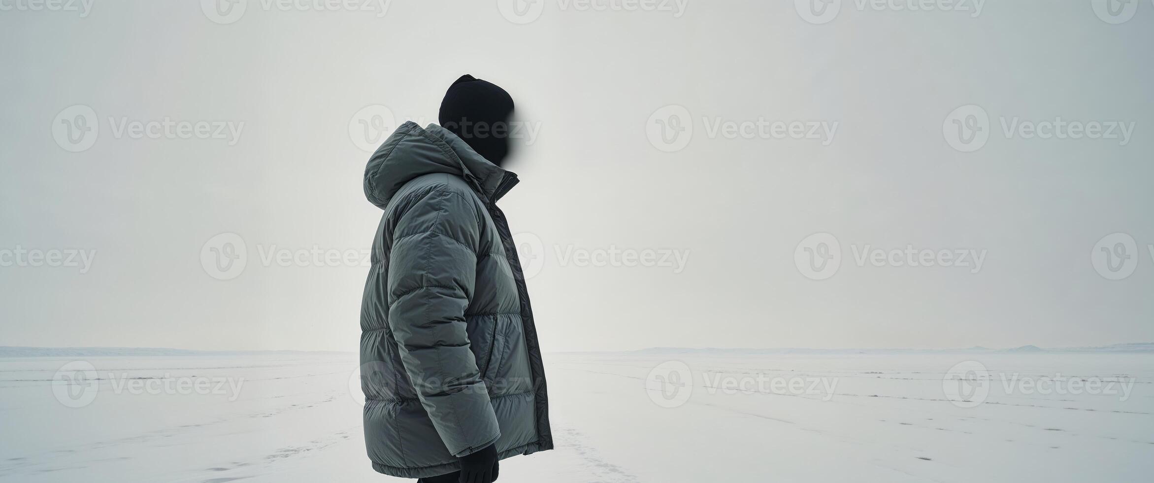 Person wearing winter jacket in snowy landscape photo