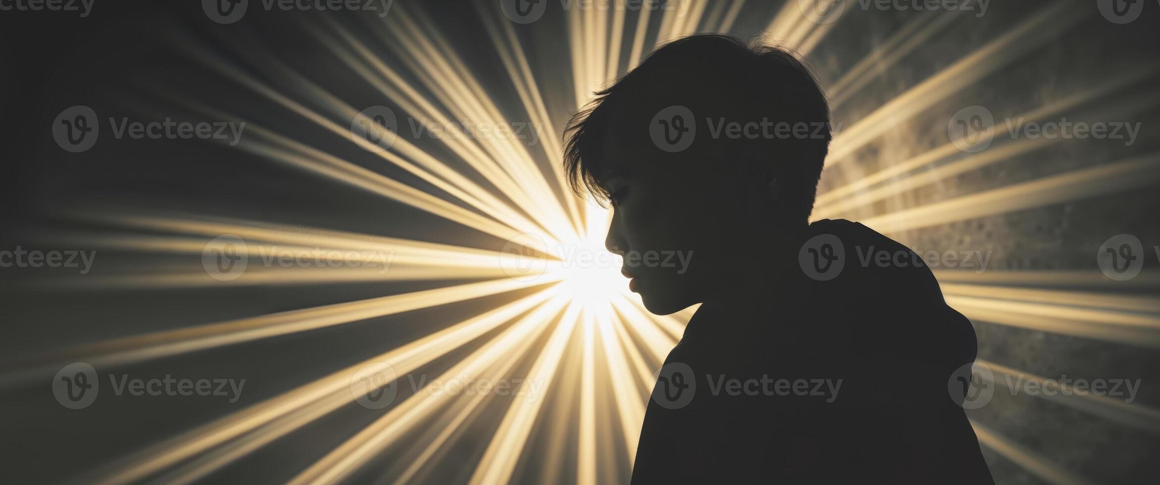 Silhouette of a Person with Bright Light Rays in a Dark Background. photo