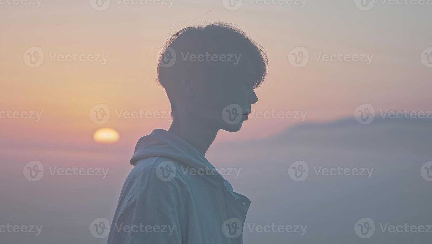 A silhouette of a person standing in front of the sun photo
