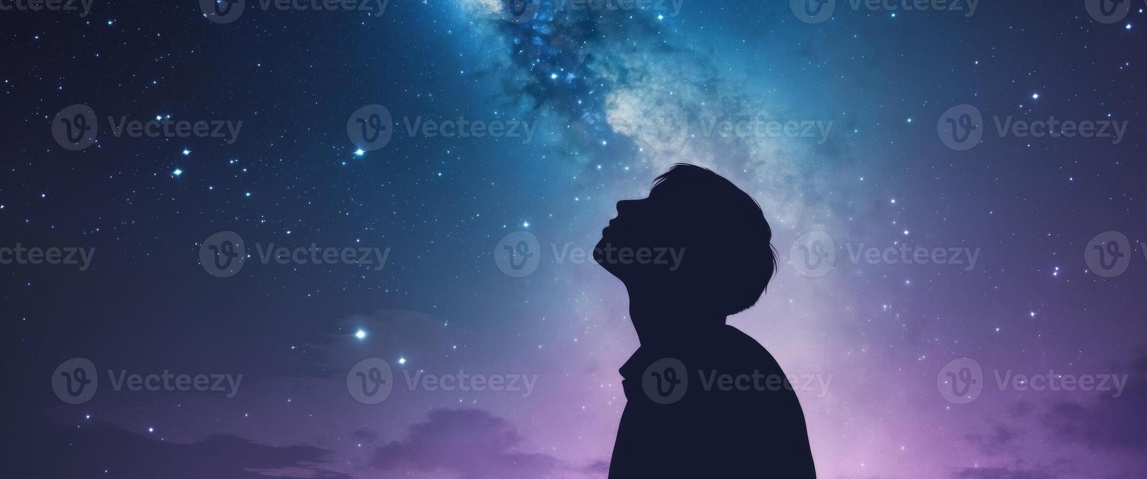 A man is looking up at the stars in the night sky photo