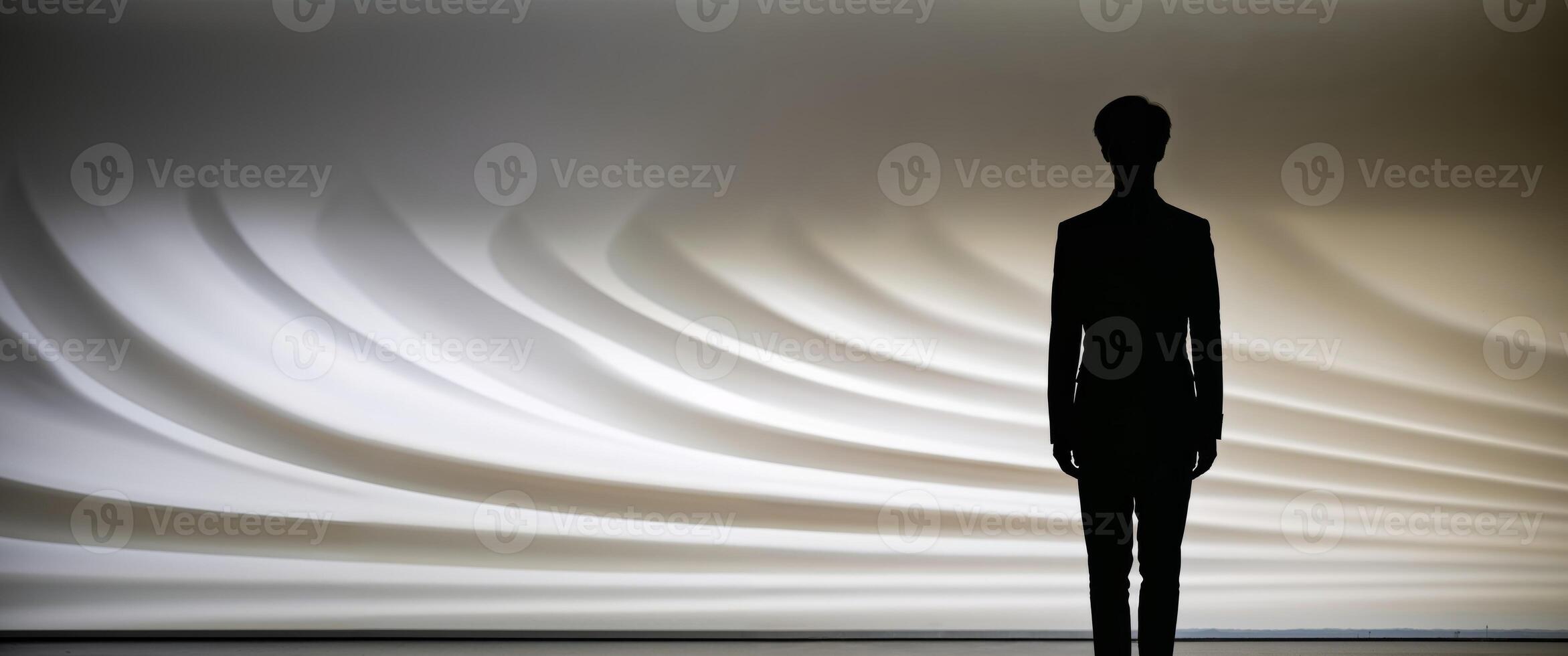 Silhouette of a man standing in front of a wall photo