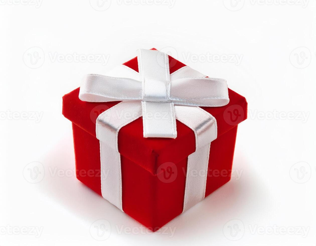 A small red gift box with a white ribbon bow on a white background perfect for holiday or special occasion photo
