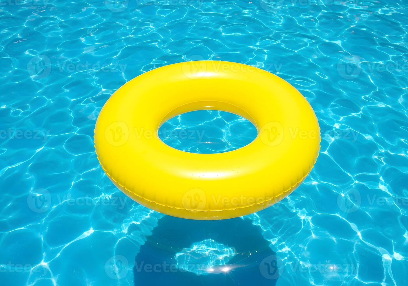 An inflatable yellow ring floating in a pool photo