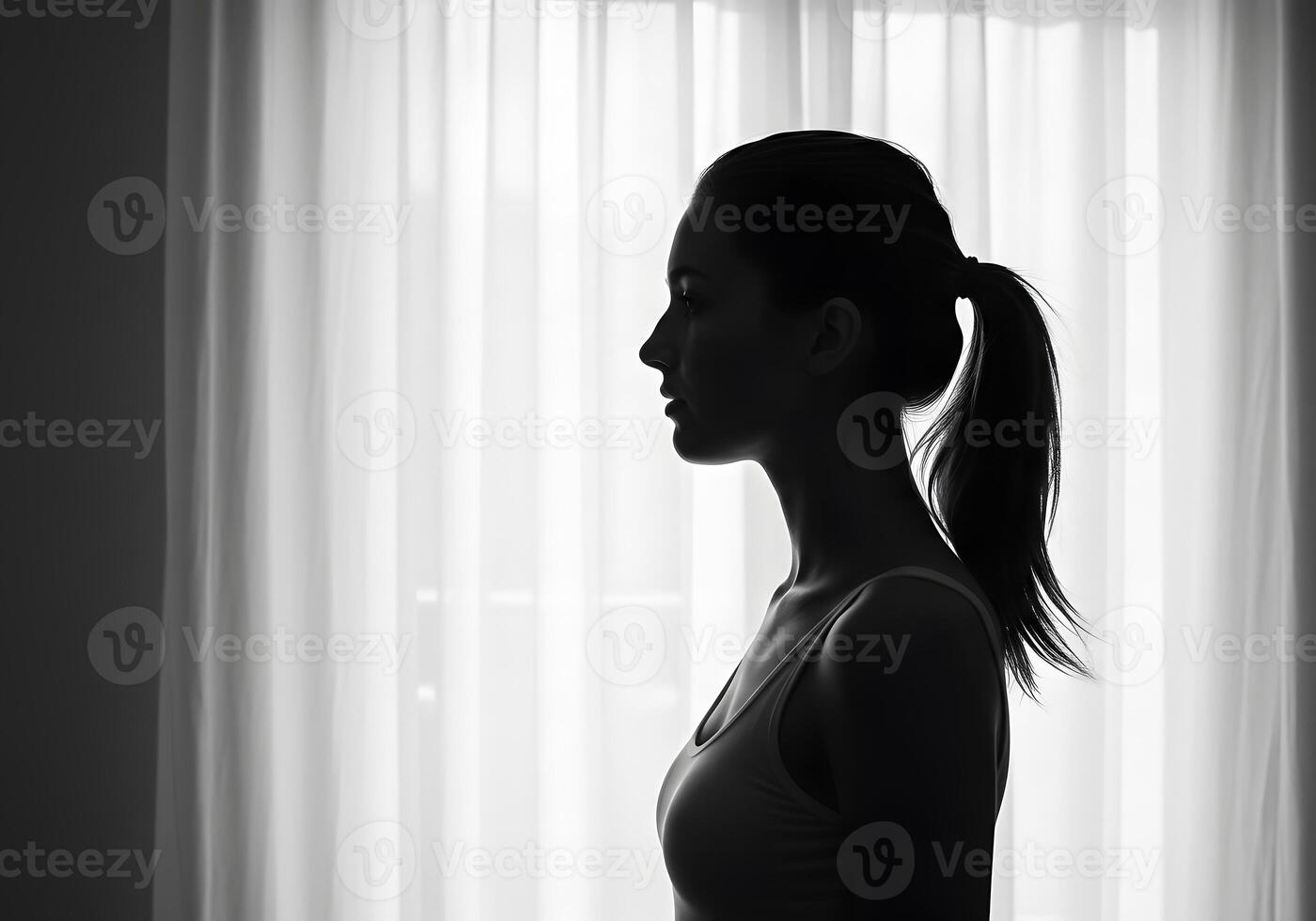 Silhouette of a woman in front of a window photo