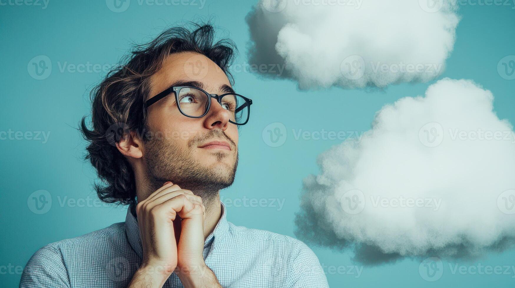 A man with glasses looking up at two clouds in the sky. photo