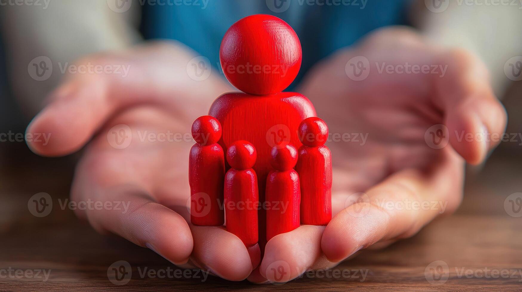 A red wooden figure of a person holding a red wooden figure of a family, with hands open and palms facing upwards, set against a wooden table with a dark brown background. photo