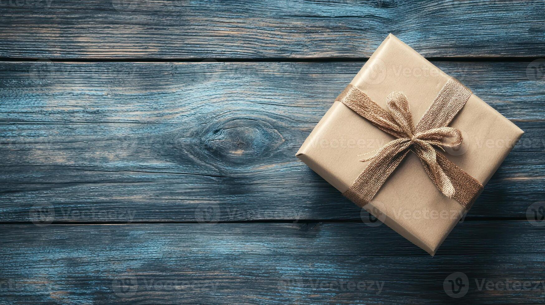 A rustic wooden table with a single gift wrapped in brown paper and tied with a string bow. photo