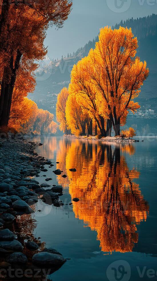 Autumn trees reflecting over calm water at an iconic lakeside location in the late afternoon light photo