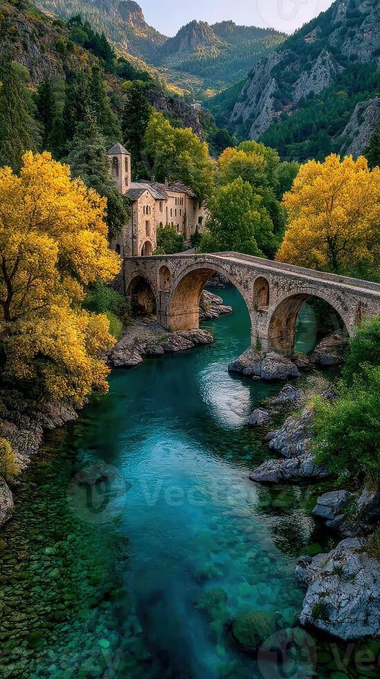 Autumn colors illuminate a historic stone bridge in a serene valley with flowing river and lush woodland photo