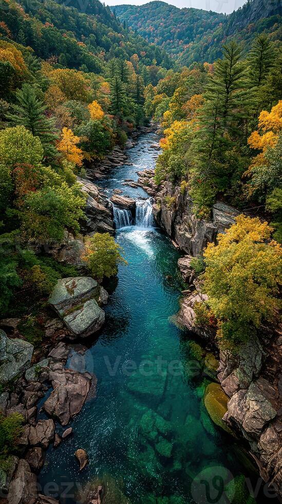 Beautiful waterfall surrounded by colorful autumn foliage flowing through rocky terrain in a serene forest setting photo
