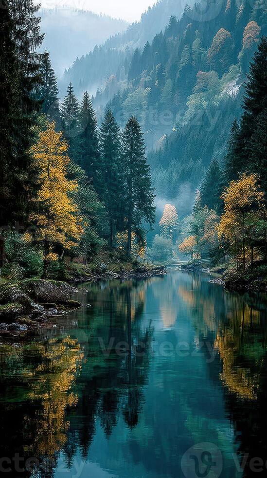 Serene river surrounded by autumn foliage and misty mountains during early morning hours photo