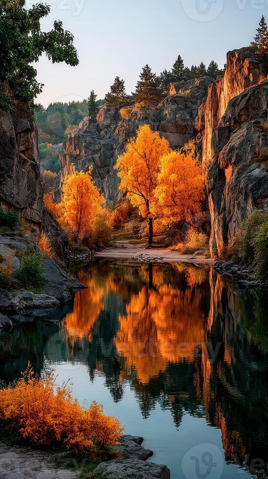 Colorful autumn trees reflect in serene river surrounded by rocky cliffs at sunrise photo