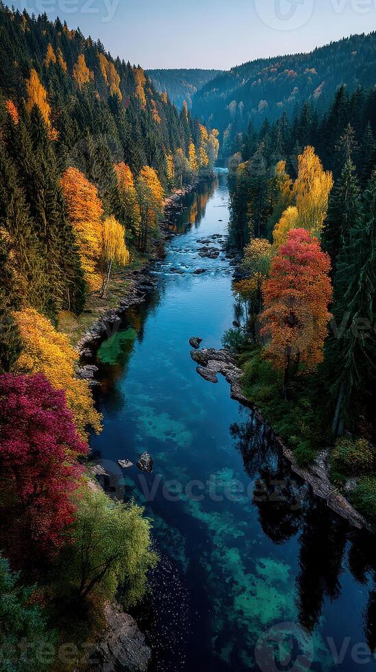 Beautiful autumn landscape with a winding river surrounded by colorful trees in the mountains at sunrise photo