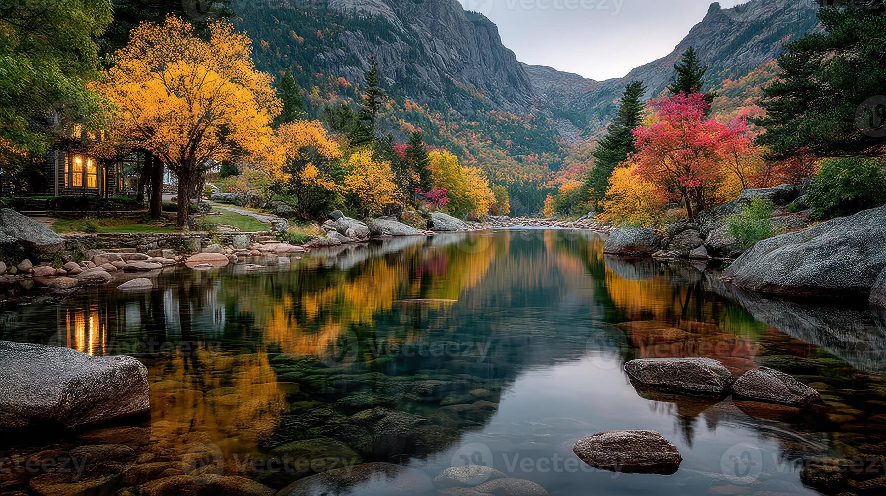 Autumn colors reflect on serene river surrounded by mountains and vibrant trees during twilight photo