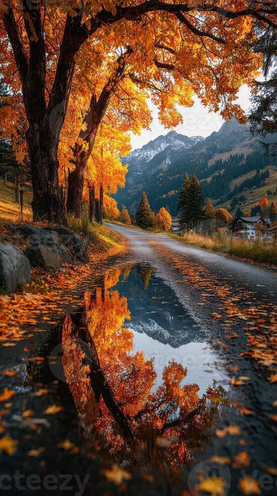 Vibrant autumn colors reflect in still water along a winding country road by the mountains photo