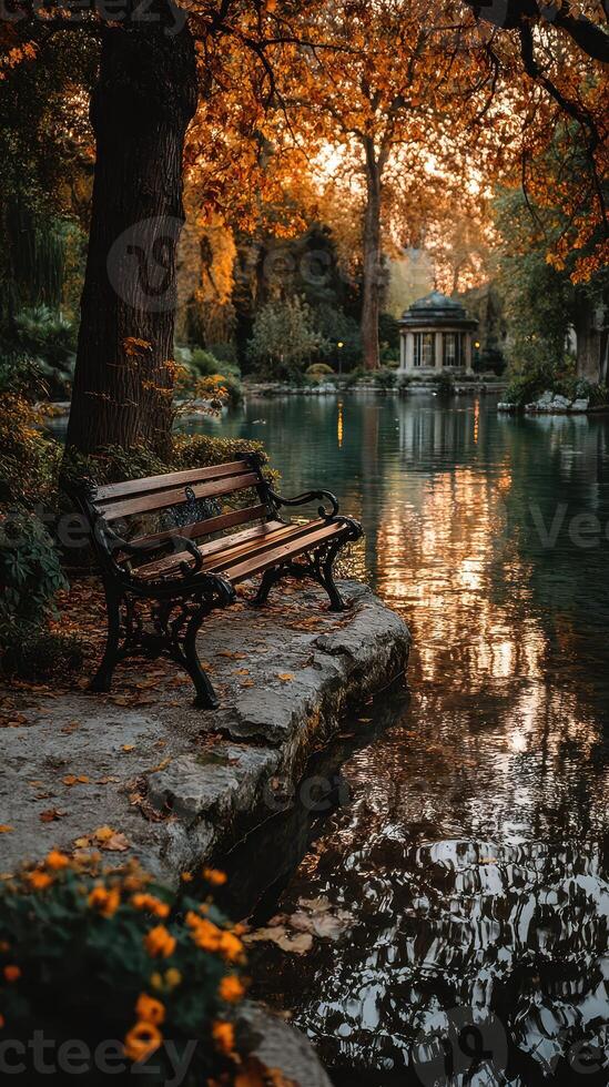 Tranquil park with a bench by a serene pond during autumn at sunset photo