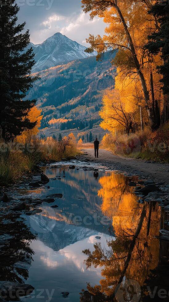 Vibrant autumn reflections on a mountain path beside a tranquil stream in Colorado photo
