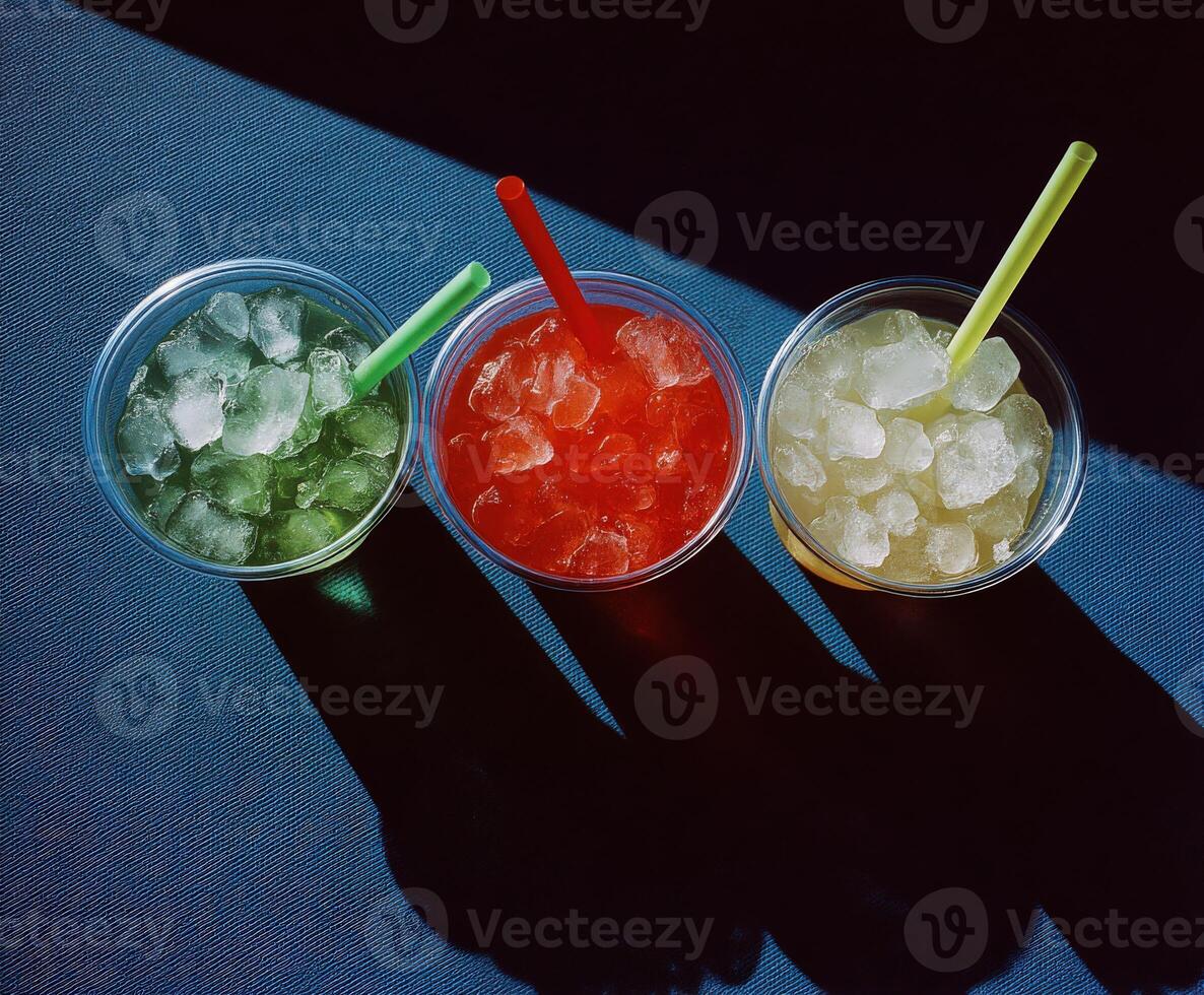 Refreshing drinks with ice in colorful cups on a table photo