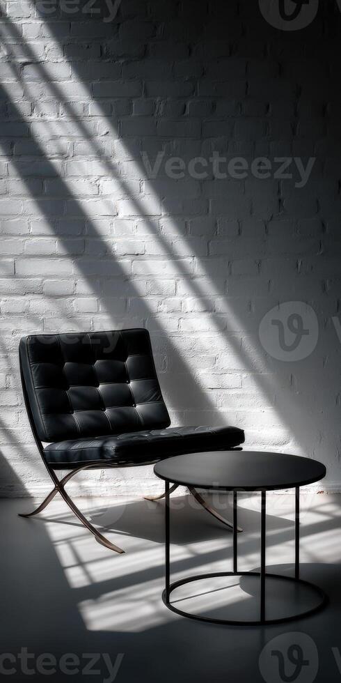 A black leather chair and table in front of a white brick wall photo
