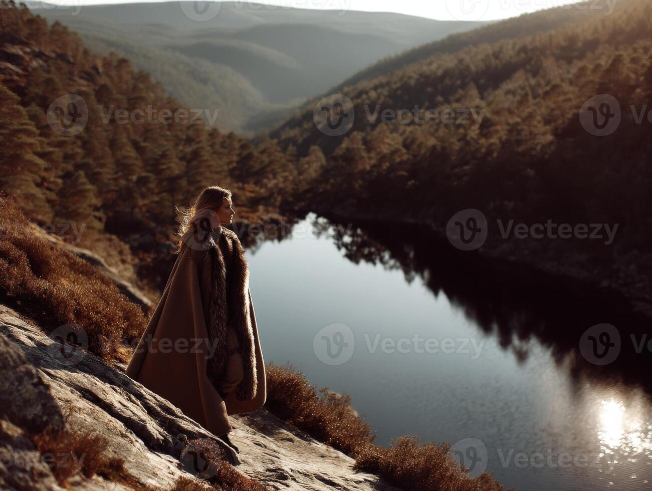 Viking woman standing by a tranquil lake in a mountainous landscape photo