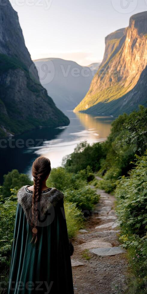 Viking woman standing by the fjord in a serene landscape at sunrise photo