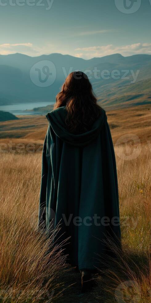 Viking woman walking through golden grasslands at sunrise photo