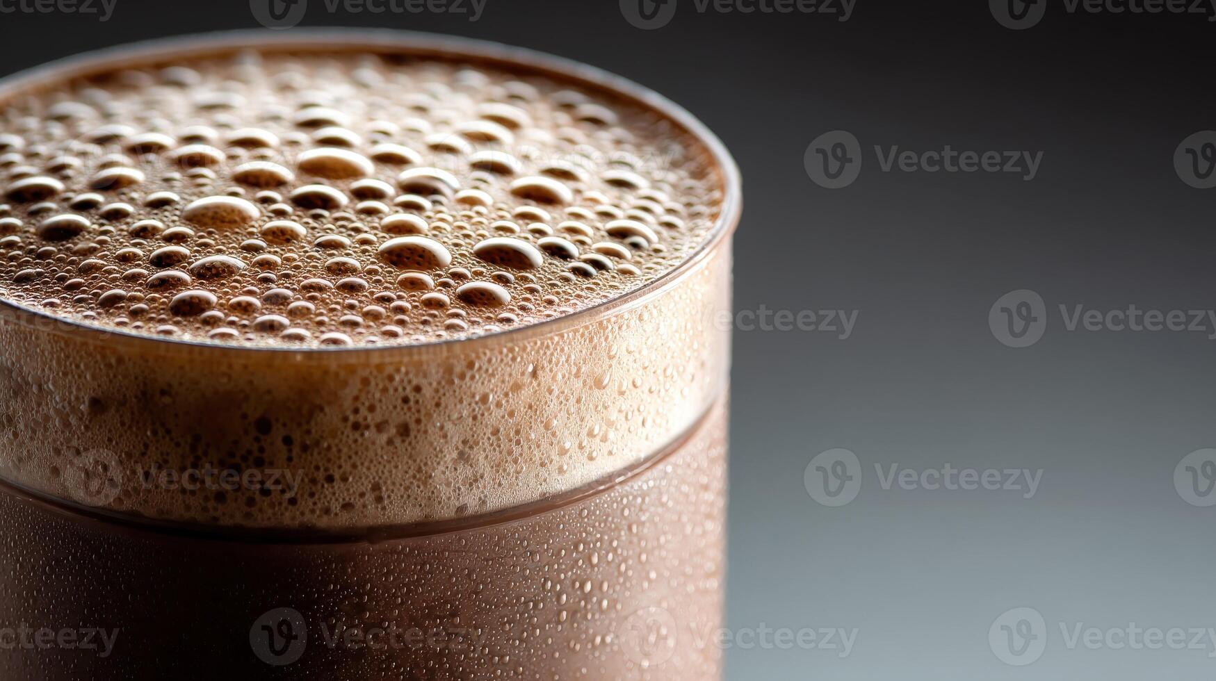 Delicious protein shake served in a clear glass with frothy bubbles photo