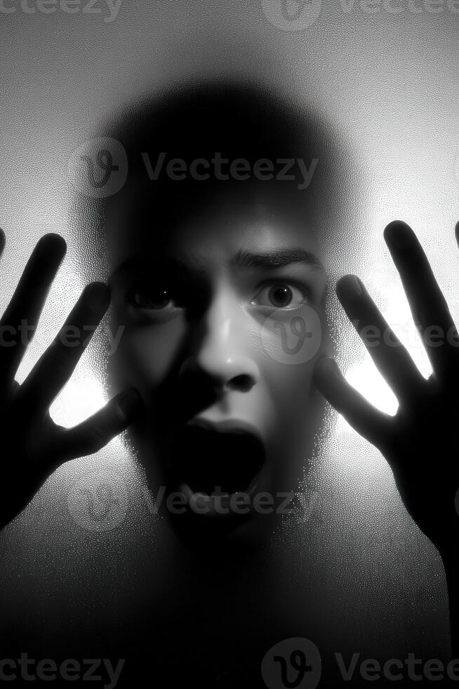 Person expresses fear while pressed against a fogged glass surface photo