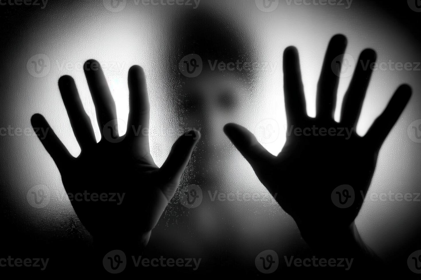 Hands pressed against a foggy surface with a silhouette behind photo
