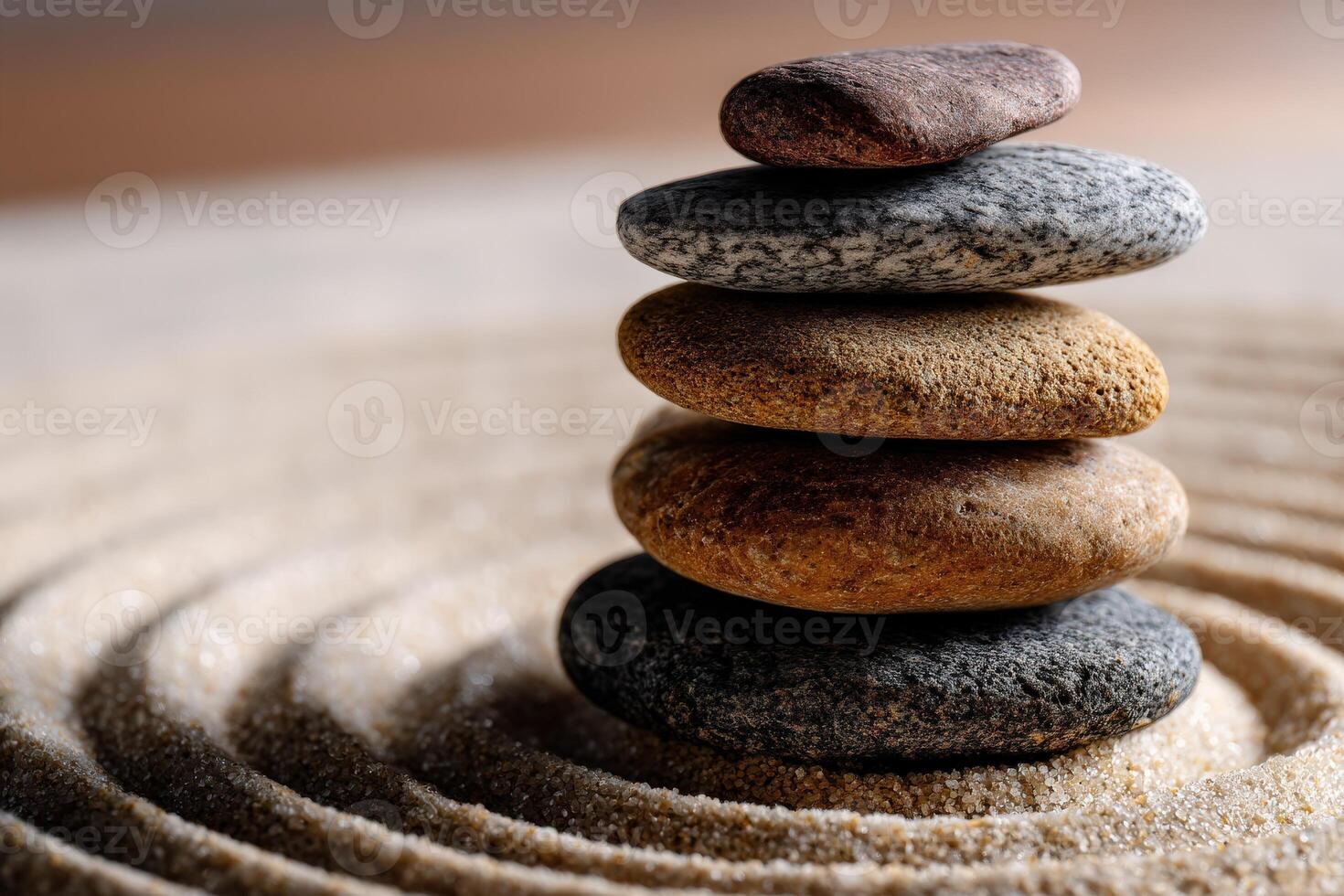Five stacked stones on a sandy surface create a calming arrangement photo