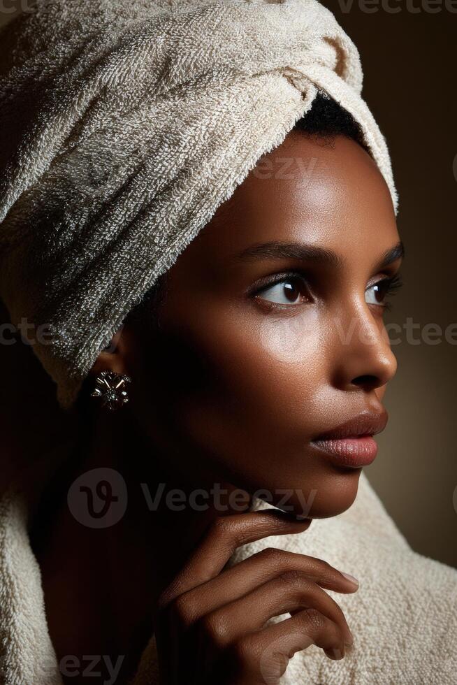Woman with a towel on her head posing elegantly in soft lighting indoors photo