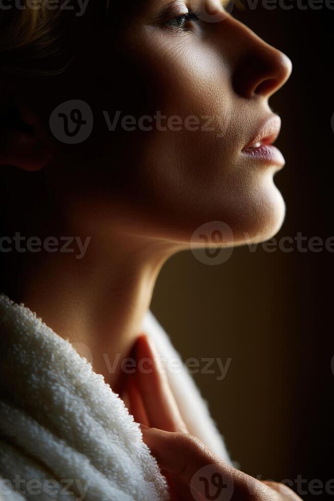 Woman in a robe contemplating in soft light during a tranquil moment photo