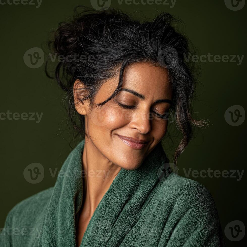Woman enjoying a peaceful moment in a cozy green robe at home photo
