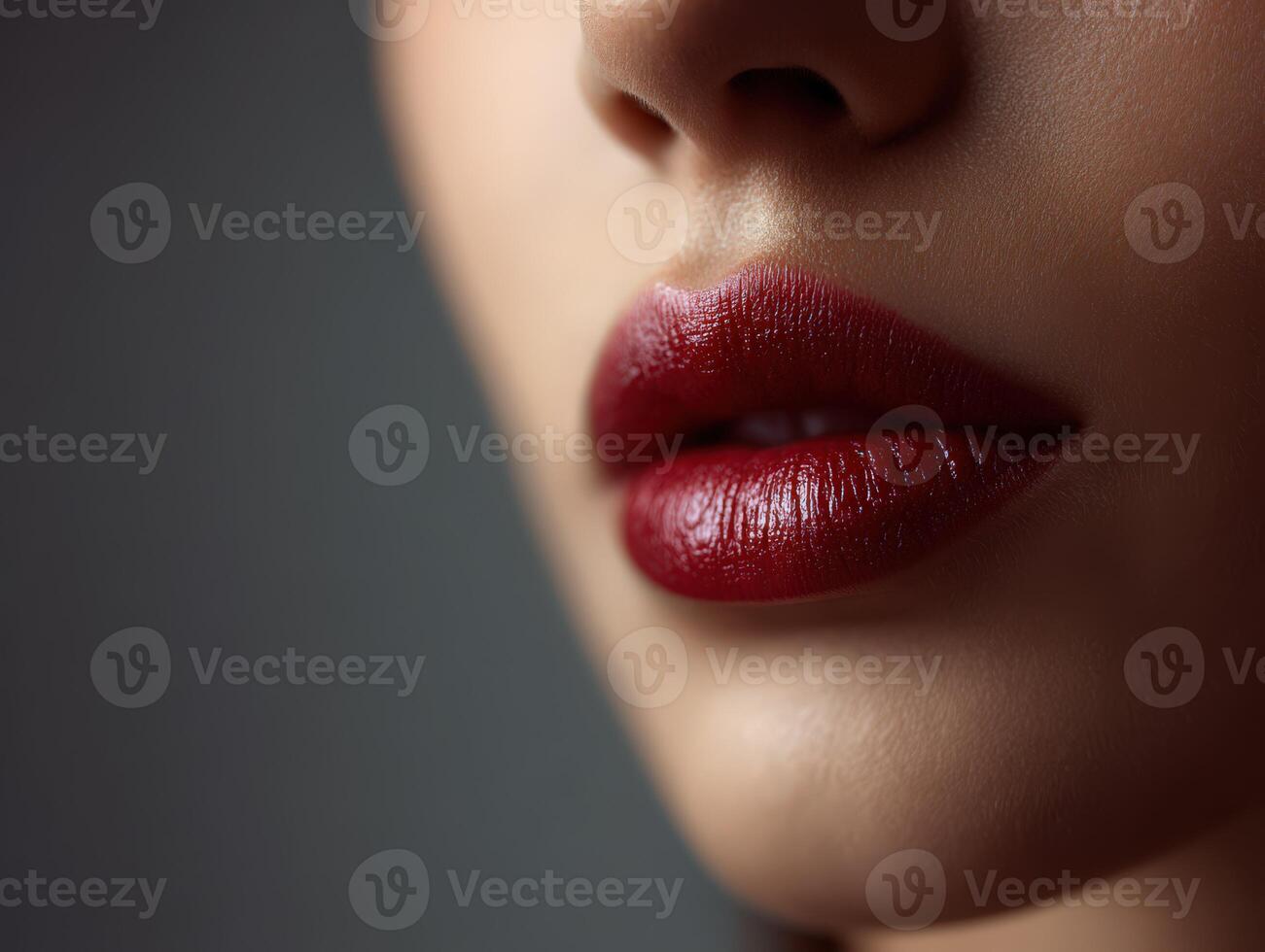 Close-up of a woman's lips adorned with deep red lipstick in soft light photo
