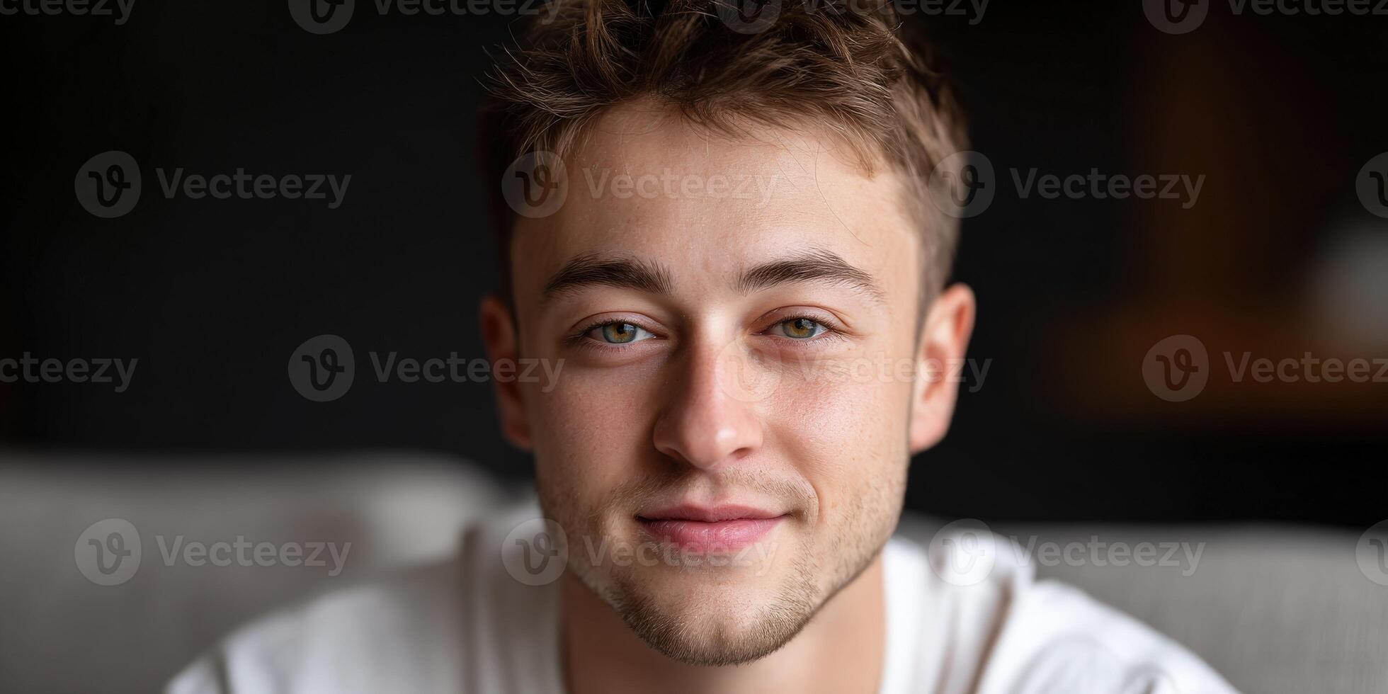 Young man smiling in cozy indoor setting with soft lighting photo