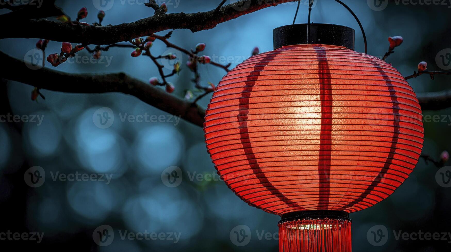 A red lantern hanging from a tree branch photo