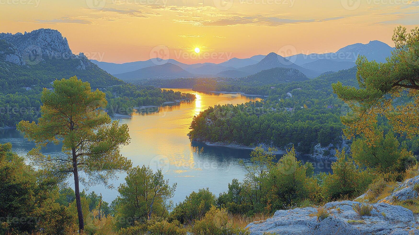 A beautiful sunset over a lake with trees and rocks photo