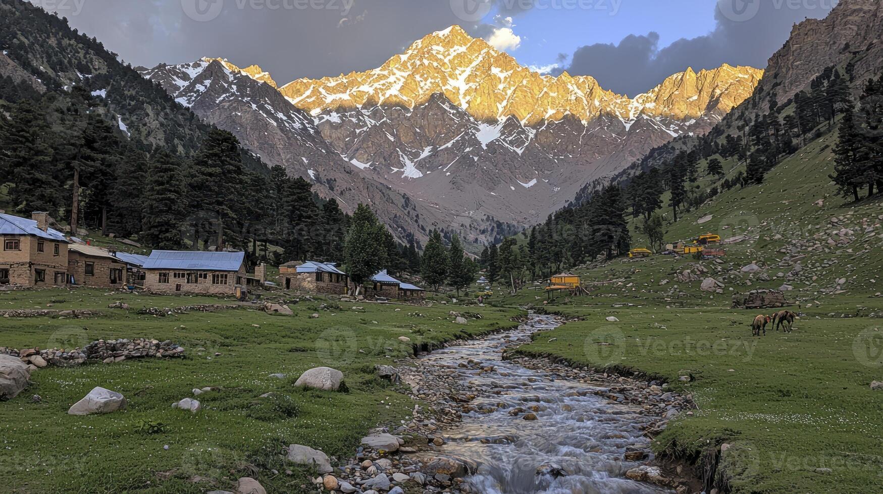 A stream runs through a valley in front of a mountain range photo