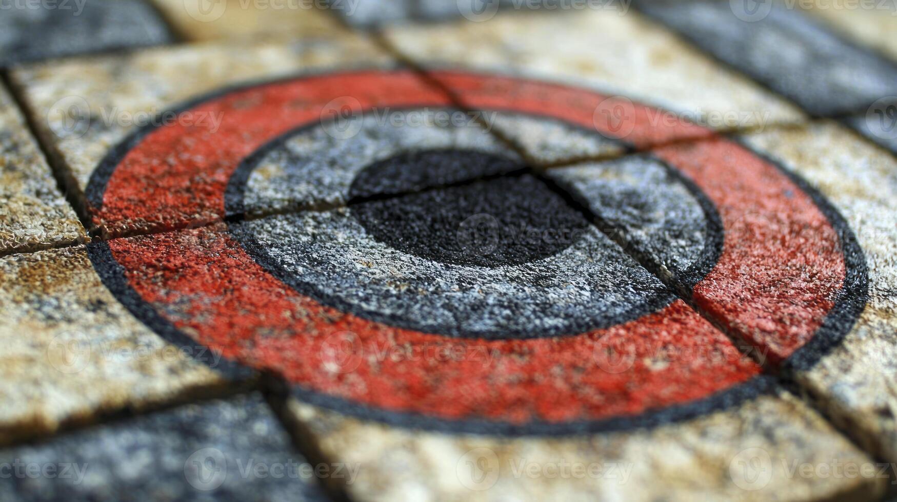 A close up of a red and black circle on a brick wall photo