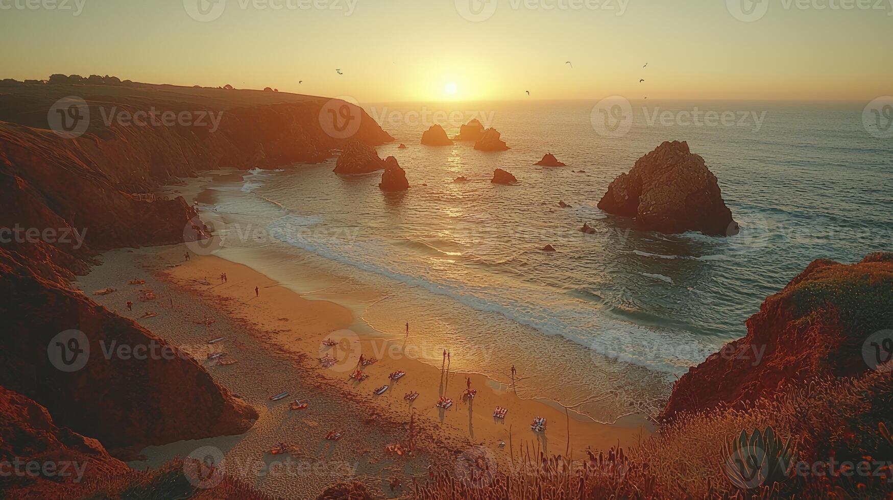 A beach with rocks and people at sunset photo