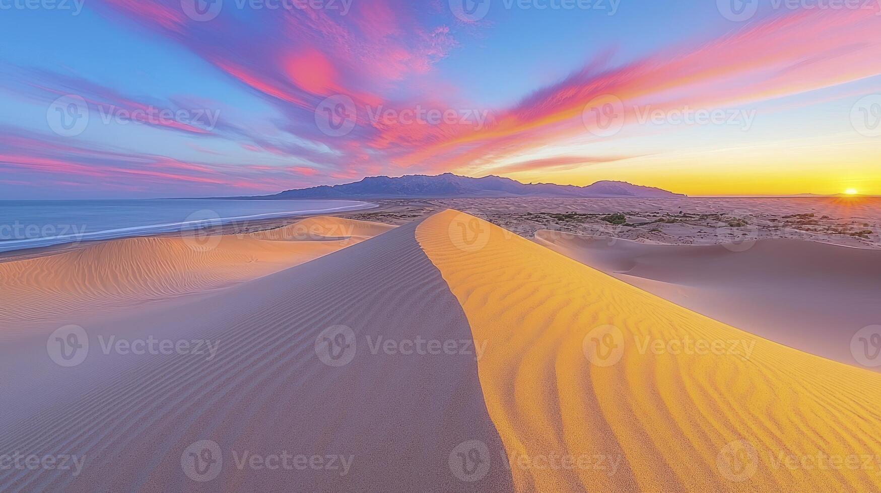 Sunset over the desert with sand dunes and mountains in the background photo