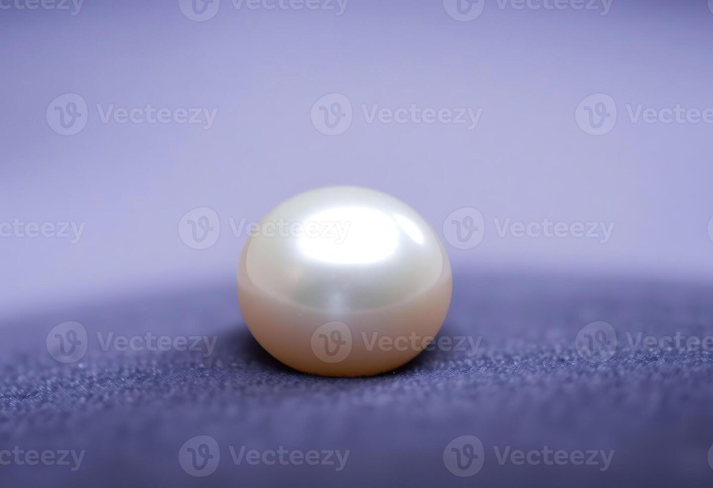 white pearl sitting on top of a purple surface photo