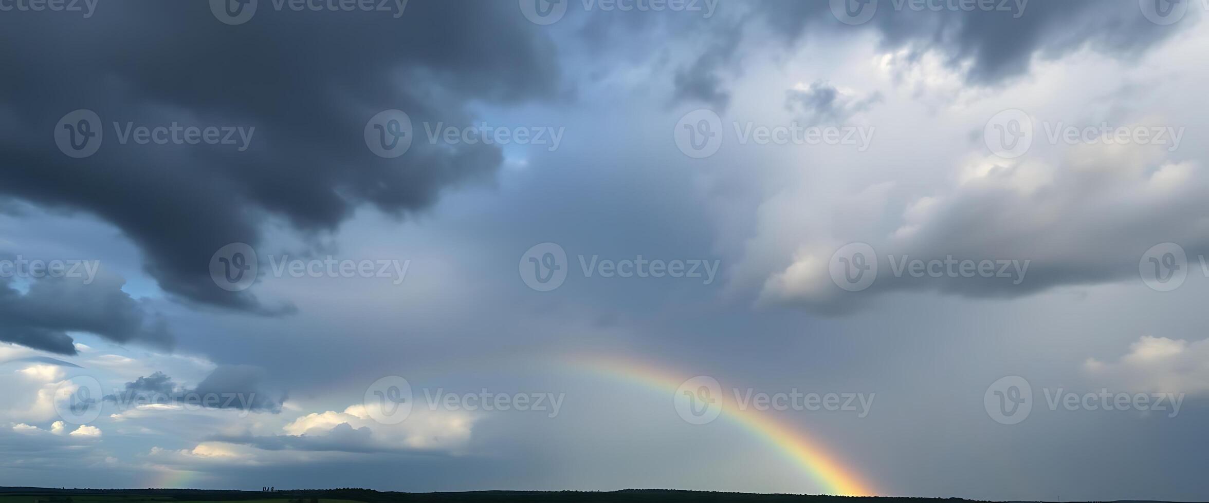 rainbow in a cloudy sky over a field photo